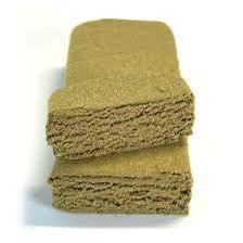 Stack of beige CBD blonde hash blocks, front view on a white background