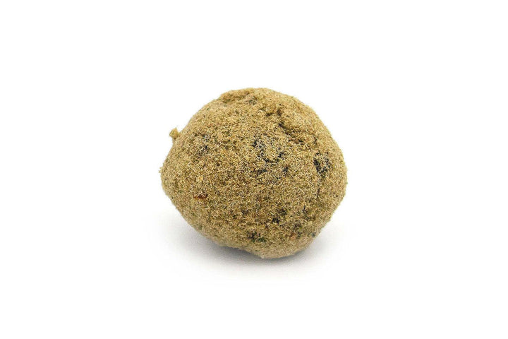 A single CBD moonrock against a white background, showing a compacted, rounded shape with a textured surface.