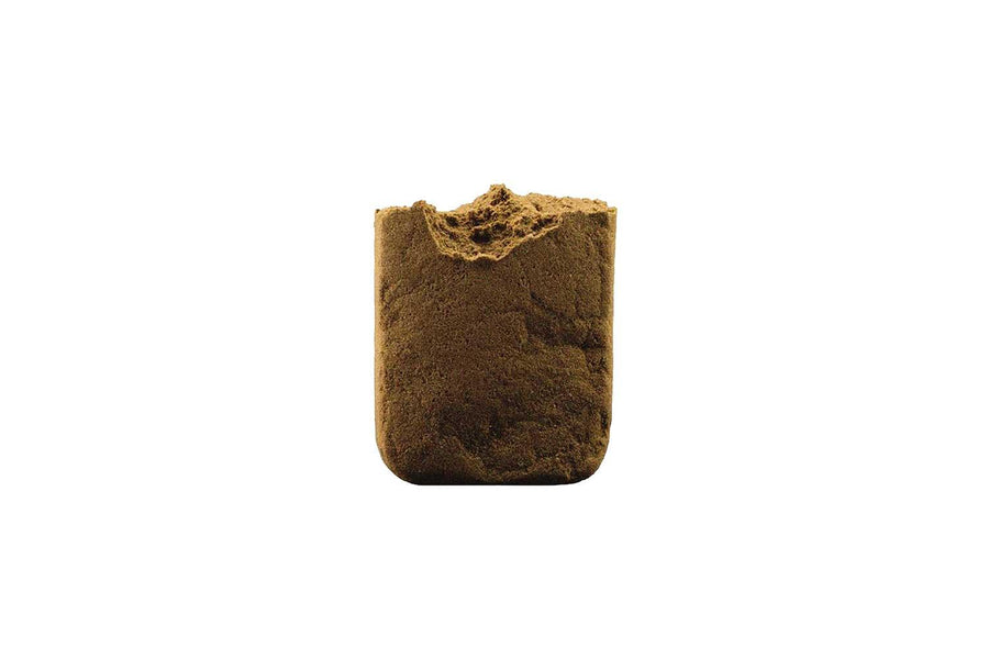 A small container of Red Lebanese CBD Hash, showing a compact, dry, brownish mass.